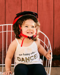 Portrait of a young girl toddler in the backyard wearing a biking helmet