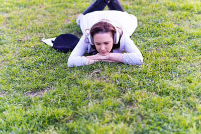 Portrait of young woman lying on grass