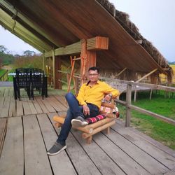 Portrait of man sitting on wood