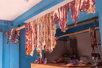 Long slices of meet hanging in the roof on road side butchery