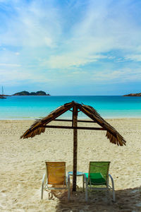 Chairs on beach against sky