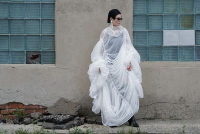 Rear view of woman standing against wall