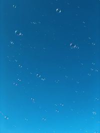 Full frame shot of bubbles against blue sky