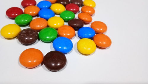 Close-up of multi colored candies against white background