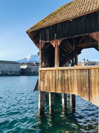Wooden posts in sea against sky