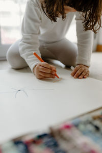 Midsection of girl drawing on table