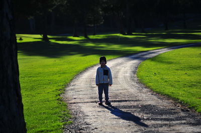 Boy standing on path in park