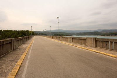 Road by bridge against sky