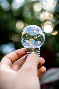 Close-up of hand holding crystal ball