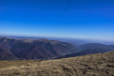 Scenic view of mountains against blue sky