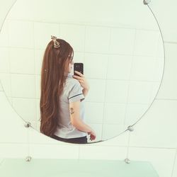 Woman photographing with mobile phone in bathroom