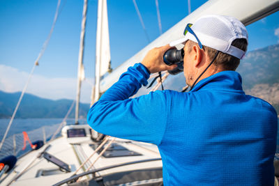 Side view of man photographing in boat