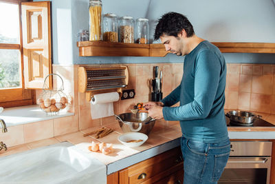 Side view of man preparing food at home