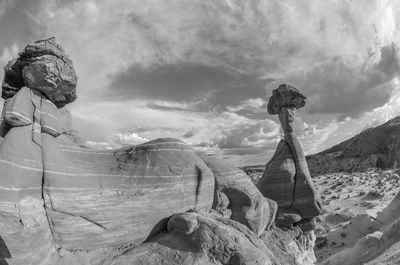 Panoramic view of cross on rock against sky