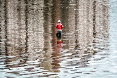 Rear view of person angling in lake