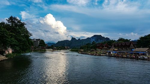 Scenic view of river by mountains against sky