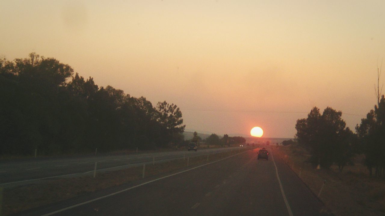 sunset, silhouette, transportation, road, tree, the way forward, tranquil scene, tranquility, sky, nature, copy space, scenics, landscape, beauty in nature, clear sky, diminishing perspective, orange color, street, dusk, outdoors