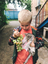 Full length of boy holding baby in park