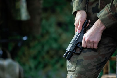 A lady soldier reloads her pistol to keep it charged during an action.