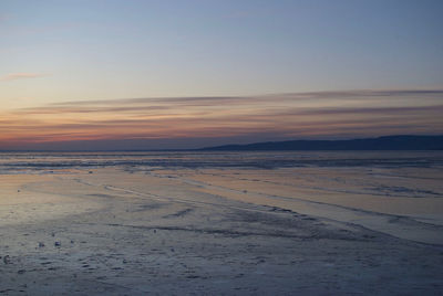 Scenic view of beach against sky during sunset