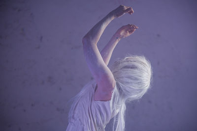 Woman performing against wall in abandoned building