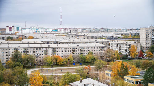 High angle view of buildings by river against sky