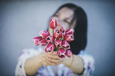 Close-up of woman holding pink flower