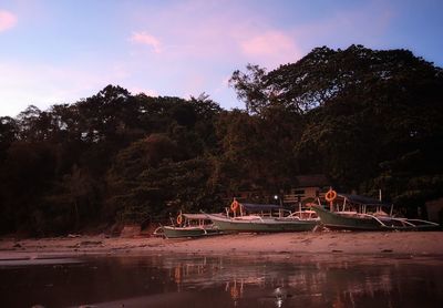 People by river against sky