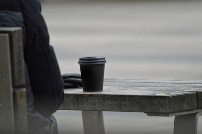 Man holding coffee cup on railing