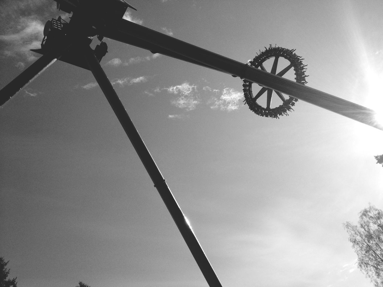 low angle view, sky, silhouette, tree, cloud - sky, metal, street light, transportation, day, connection, outdoors, cloud, pole, technology, sunlight, no people, nature, lighting equipment, cloudy, metallic