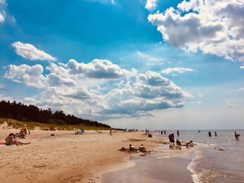 Group of people on beach against sky