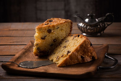 Slices of home made cake with raisins on wooden plate, vintage style