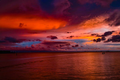 Scenic view of sea against dramatic sky during sunset