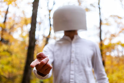 Man holding umbrella standing by trees during autumn