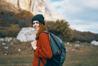 Portrait of smiling young woman standing in park during winter