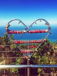 Close-up of padlocks on heart shaped railing