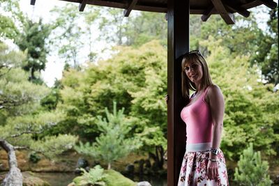 Woman standing by trees in park