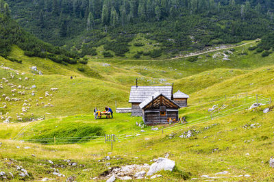 Built structure on field by trees and mountain