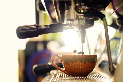 Close-up of coffee pouring in cup at cafe