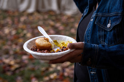 Close-up of person holding warm bowl of food