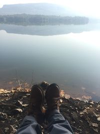 Low section of man on rock against lake