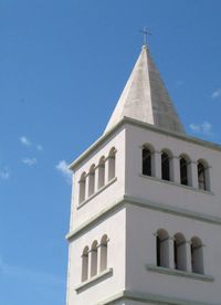 Low angle view of bell tower against blue sky