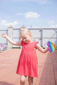 Cute girl with pink arms raised