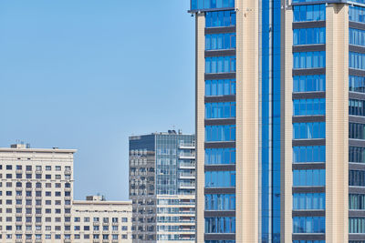 Low angle view of modern buildings against clear blue sky