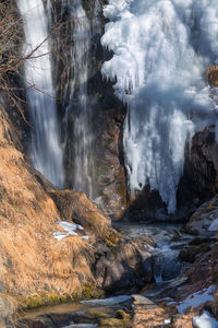 Water splashing on rocks against sky