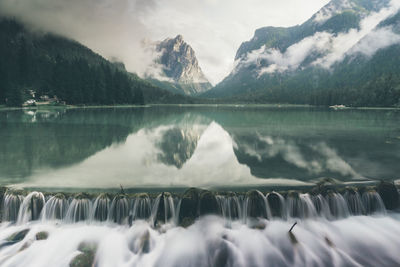 Scenic view of lake by mountains against sky