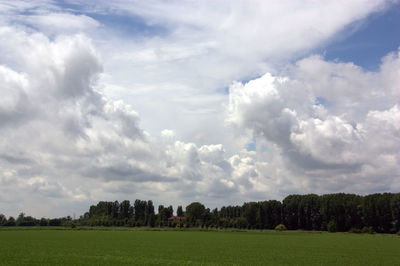 Scenic view of field against cloudy sky