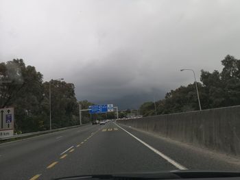 Road amidst trees against sky during rainy season