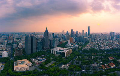 Aerial view of buildings in city against sky during sunset