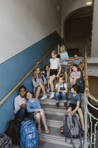 Multiracial male and female students on school staircase